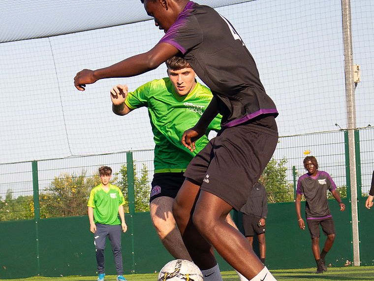 Two players contest the ball during a 7-a-side Street Trials match