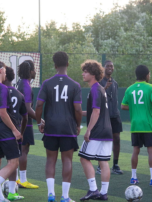 Trialists gather on the pitch for a team briefing